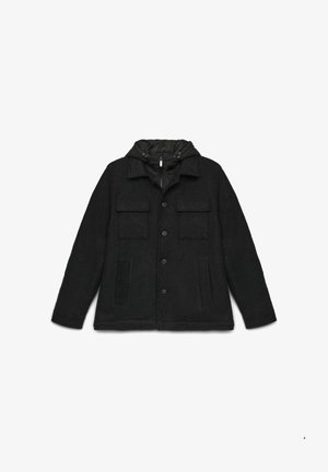 Veste noire avec un extérieur en laine, une capuche noire rembourrée, une fermeture à boutons, deux poches poitrine et deux poches latérales. Texture douce et coupe décontractée.