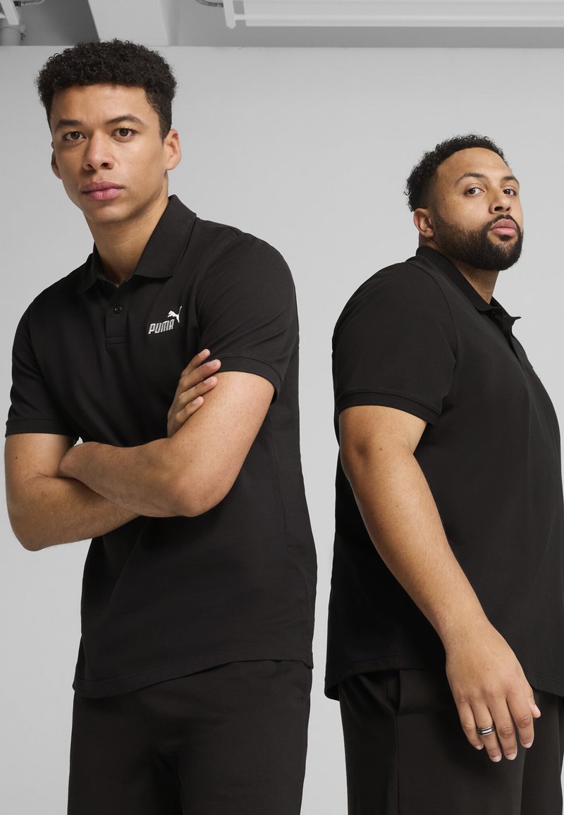 Polo shirt nera in tessuto misto cotone, con maniche corte e colletto classico, con il logo bianco Puma sul petto sinistro.