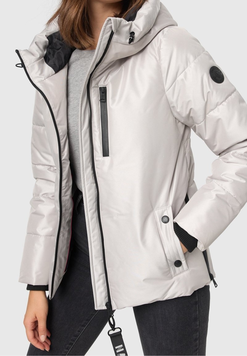 Ljusgrå puffjacka med huva, som har svarta detaljer, fickor med dragkedja, texturert tyg och knäppdetaljer.