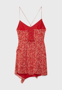 Abito rosso floreale con schiena con lacci, spalline sottili e orlo asimmetrico con tessuti sovrapposti per una maggiore texture.