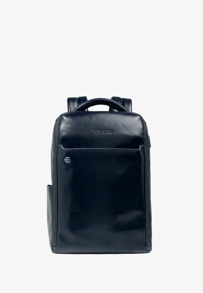 Mochila de cuero azul marino con un acabado brillante, cuenta con un bolsillo frontal con cremallera, asas resistentes y correas ajustables. Diseño minimalista.