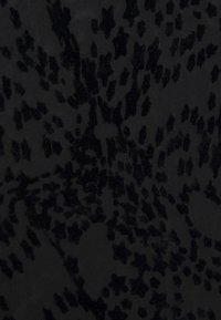 Schwarzer Stoff mit unregelmäßigen, strukturierten Samtblumen- und Punktemustern auf einem glatten, matten Hintergrund.