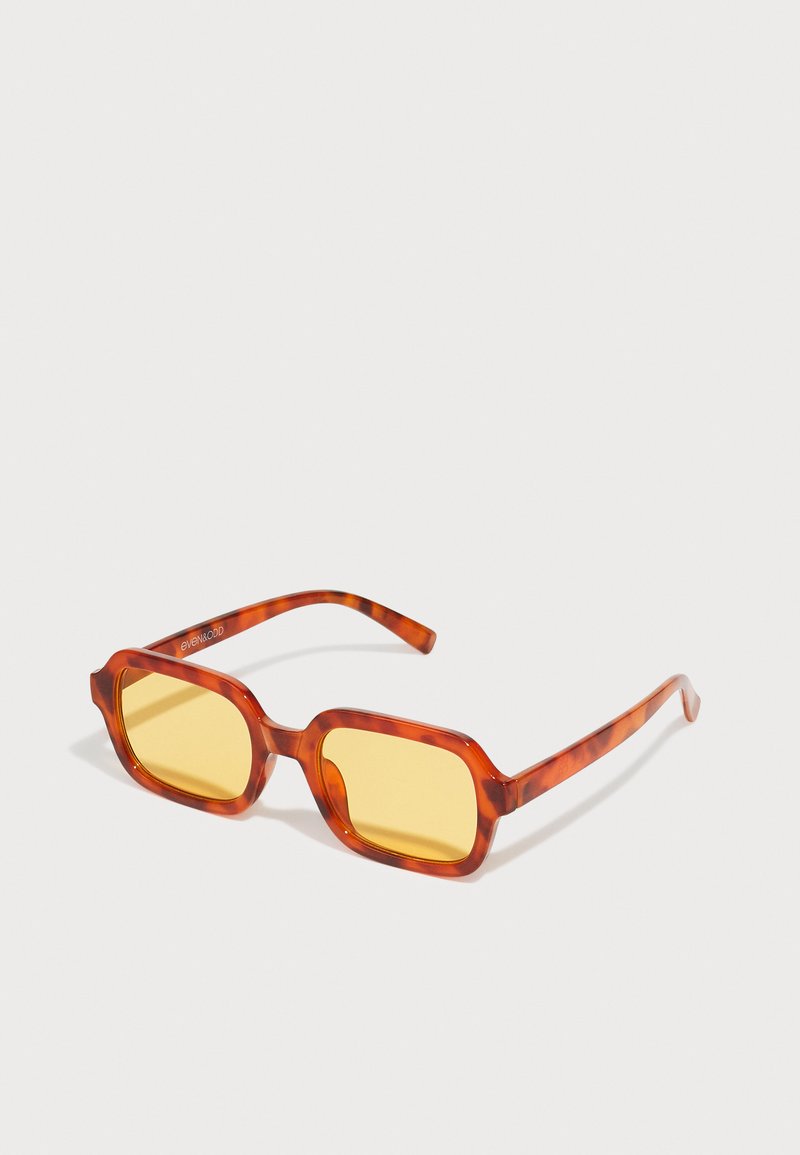 Óculos de sol retangulares com armações em padrão tartaruga de cor vermelha e lentes amarelas. Textura suave com hastes retas.