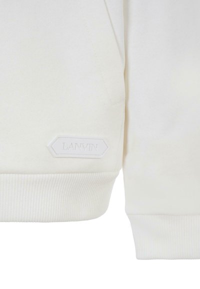 Tessuto bianco del sudore con polsini e orli a costine. Presenta un'etichetta in rilievo bianca e testurizzata con la scritta "LANVIN" in forma esagonale.