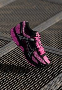 Nike dámska bežecká obuv s čiernym zvrškom a ružovými akcentmi, sieťovanými panelmi, hrubou podrážkou a výrazným logom swoosh.