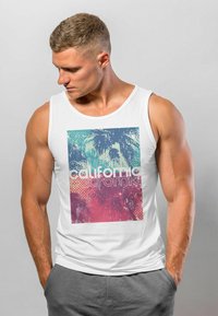 Weißes ärmelloses Tanktop mit einem bunten Grafikdesign, das Palmen und das Wort "California" in fetten Buchstaben zeigt, leichte Textur.