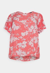 Blouse corail à manches courtes avec un motif floral en blanc et rose clair, fabriquée dans un tissu léger et à coupe ample.