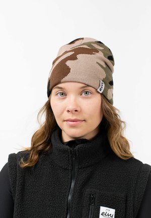 Knitted camouflage beanie in beige, brown, and green. Soft texture with a rolled hem and a small logo tag on the side.