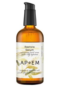 Bernsteinfarbene Glasflasche mit schwarzem Pumpspender. Das Etikett zeigt einen weißen Hintergrund, grüne botanische Illustrationen und Text, der den Produktnamen und die Inhaltsstoffe beschreibt.