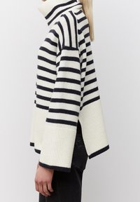 Sweter w paski w białym i granatowym kolorze z wysokim kołnierzem, szerokimi rękawami, prążkową teksturą i luźnym krojem. Wyraźny design z opuszczonymi ramionami.