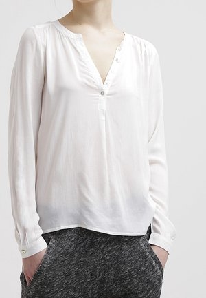 Camicia bianca a maniche lunghe con scollo a V e bottoni, realizzata in tessuto leggero, con un fit rilassato e una leggera lucentezza.