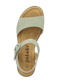 Sandalo in pelle verde chiaro con un elemento circolare, soletta in morbido color nocciola e suola marrone. Cinghia regolabile per una vestibilità sicura.