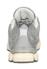 Grijze sportieve schoen met een gestructureerde bovenkant, netpanelen en suède accenten. Beschikt over een gevoerde hiel en een contrasterende beige buitenzool.