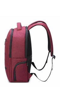 Mochila de tela roja con un acabado texturizado, detalles en negro, correas acolchadas y múltiples compartimentos con cremallera en los laterales y en la parte frontal.