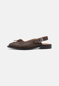 Brūna ādas slingback kurpe ar platu papēdi, noapaļotu purngali un auklu priekšpusi, kā arī sudraba sprādzi uz siksniņas.