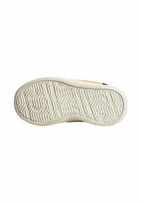 Suola in gomma con un motivo testurizzato a zigzag beige. La parte superiore presenta un accento giallo brillante e un dettaglio nero sul tallone.