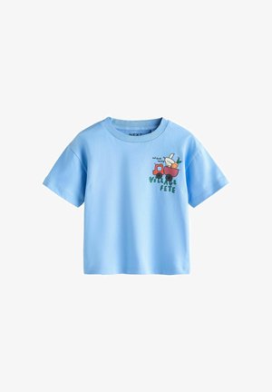 Šviesiai mėlynas trumpomis rankovėmis kūdikio marškinėliai su raudonu sunkvežimiu, vežančiu kiškį ir morką, tekstu „On our way“ ir „Village Fete“.