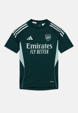 Zielona koszulka z krótkim rękawem, wykonana z gładkiego materiału, z białym logo "Emirates", herbem Arsenalu i trzema białymi paskami na ramionach.