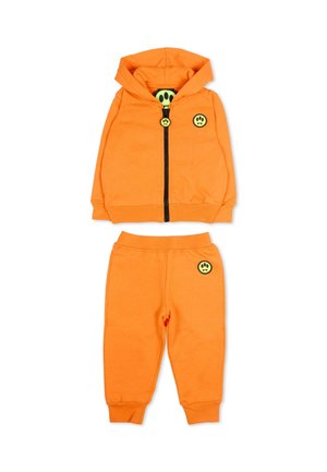 Oranje peutertrainingspak met gewatteerd jack met capuchon en ritssluiting en broek, beide met kleine gele smiley-patch.