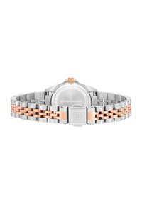 Reloj de acero inoxidable con un acento en oro rosa en la pulsera. Presenta un cierre en tono plateado y una corona naranja. La parte posterior muestra detalles de la marca y el material.