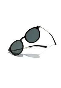 Ochelari de soare ovali negri cu lentile închise, un cadru gros din plastic și brațe subțiri din metal. Designul este minimalist, fără modele vizibile.
