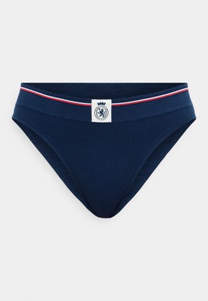 Tumšo zilā kokvilnas bikini apakšveļa ar mīkstu elastīgu jostasvietu, kurai ir sarkani un zili svītras; priekšpusē ir logotipa uzlīme.