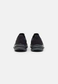 Zapatillas deportivas negras con parte superior de malla, acentos texturizados y suelas de goma flexibles. Presenta un cuello acolchado y un diseño minimalista.