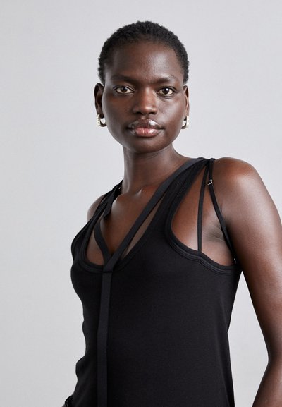 Fekete ujjatlan felső, testre szabott fazonnal, hálós részletekkel és pántos díszítéssel. Könnyű anyagból készült, sima tapintással.