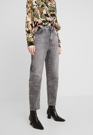 Jeans gris taille haute à jambe droite en denim, dotés d'un délavage léger et d'un design à cinq poches, associés à des bottines noires.