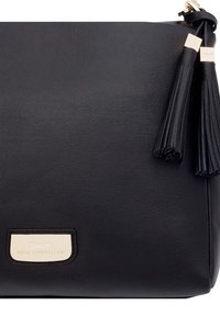 Zwarte leren handtas met een gladde textuur, voorzien van twee decoratieve kwastjes en een goudkleurig merkembleem aan de voorkant.