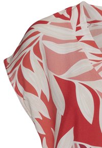 Blusa a scollo a V con maniche corte, caratterizzata da un motivo floreale in rosso e crema. Realizzata in tessuto leggero, con una texture liscia.