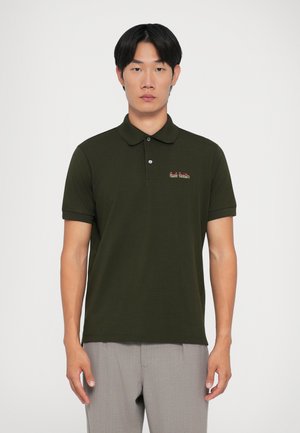 Mörkgrön polo-skjorta med klassisk krage, korta ärmar och en subtil broderad logotyp på bröstet. Mjuk tyg med en slim fit-design.