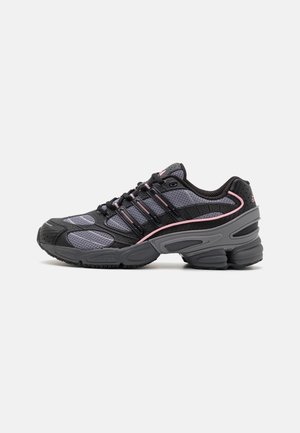 Le scarpe sportive nere e grigie presentano una tomaia in rete, una suola in gomma e dettagli rosa. Il design include una punta arrotondata e schemi testurizzati.