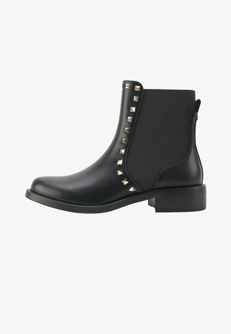 Stivaletti neri in pelle sintetica con lati elasticizzati, caratterizzati da borchie a forma di piramide lungo il lato esterno e un tacco basso e impilato.