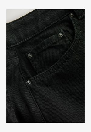 Schwarzer Denimstoff mit strukturierter Oberfläche. Verfügt über Metallnieten an den Taschen und verstärkte Nähte entlang der Kanten.