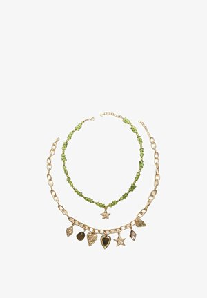 Guldtonet metal kæde halskæde lagdelt med en grøn perlesnor, prydet med stjerne- og bladcharms, der har forskellige former og teksturer.