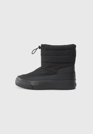 Botte d'hiver noire mi-mollet avec tissu matelassé, semelle en caoutchouc et fermeture ajustable par cordon en haut.