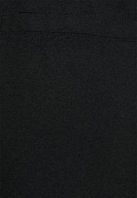 Černá tkanina s texturovaným povrchem, s jemným tkaným vzorem a zesíleným švem podél okrajů. Vhodná pro různé použití.
