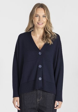 Granatowy sweter z dzianiny z dekoltem w serek, opadającymi ramionami, trzema dużymi guzikami i prążkowanymi mankietami. Wyraźne dwa przednie kieszenie.