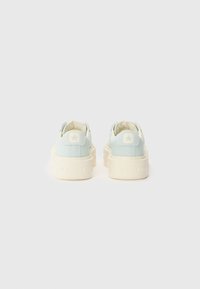 Világoskék és krém színű alacsony szárú sneaker, texturált vászon felsőrésszel, gumitalppal és domború csillaglogóval a sarokrészen.