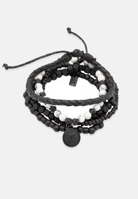 Daugiasluoksnis apyrankė, featuring juodas ir baltas karoliukas, pintas juodas virvutė ir apvalus, iškeltas žymeklis. Apima lygius ir tekstūruotus paviršius.