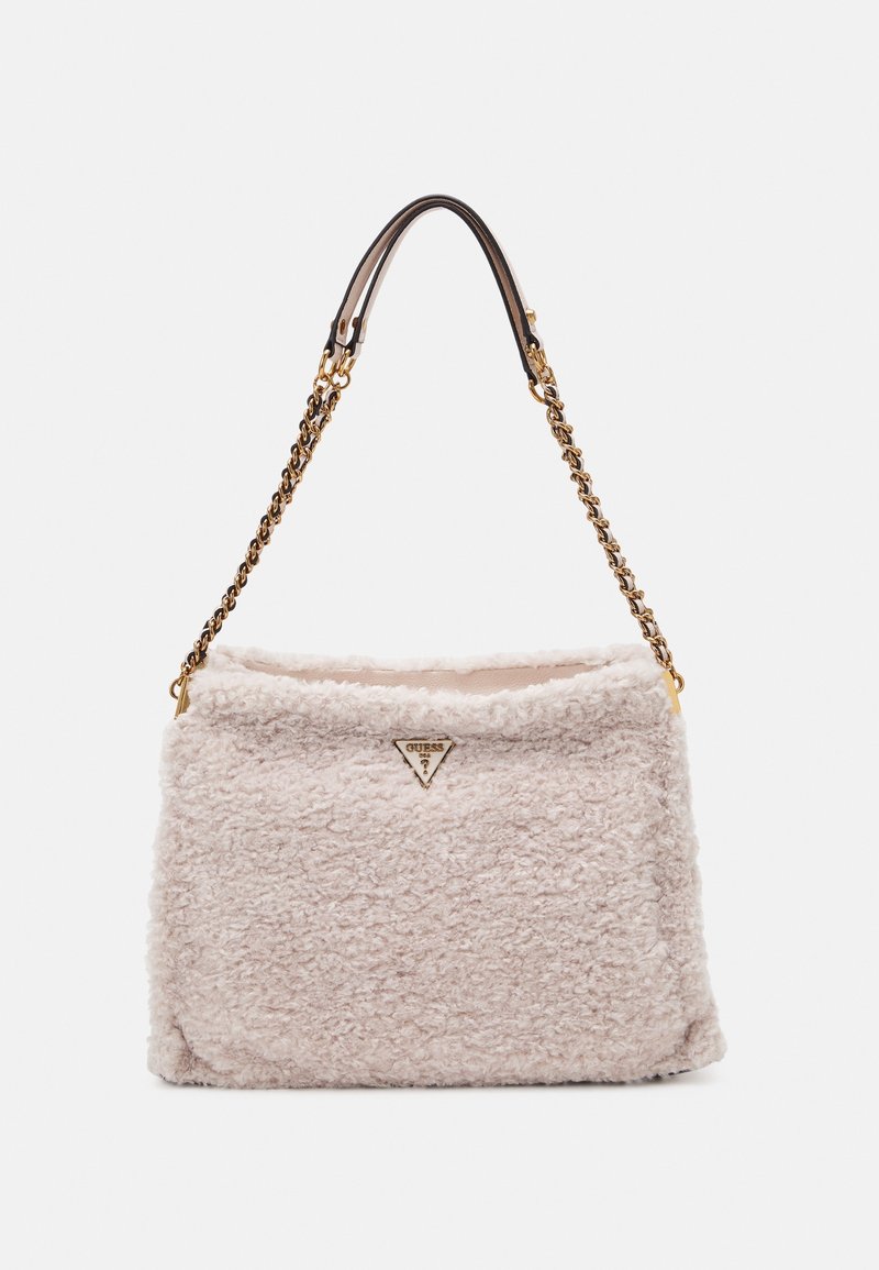 Sac à main couleur crème à texture douce avec chaîne dorée et bandoulière en cuir, doté d’un petit logo triangulaire Guess sur le devant.