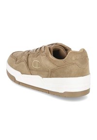 Bruine suède sneakers met een witte rubberen zool en gestructureerde accenten, voorzien van een toon-op-toon logo aan de zijkant en een gewatteerde kraag voor comfort.