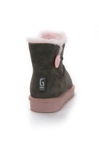 Botín de ante gris con forro interior rosa y suela de goma. Presenta un botón rosa redondo y un logotipo en la parte trasera.