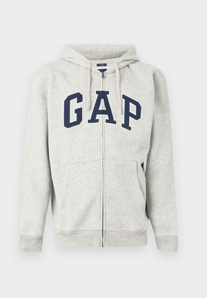 Light gray zip-up hooded sweatshirt with navy blue "GAP" lettering across the chest and front split pockets.