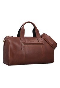 Braune Leder-Duffle-Tasche mit doppelten Tragegriffen, verstellbarem Schultergurt, goldenem Reißverschluss und einer Vordertasche. Glatte Textur und runde Form.
