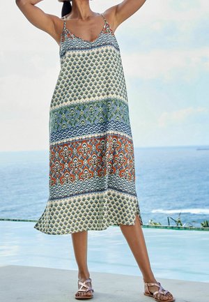 Vestido ligero sin mangas con un patrón floral en azul, verde, naranja y crema; incluye aberturas laterales y tirantes finos.