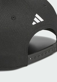 Gorra negra de tela texturizada con un logo blanco de Adidas, visera curva y cierre ajustable tipo snapback con múltiples orificios.