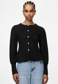 Czarny kardigan z prążkowanego materiału o okrągłym dekolcie, długich bufiastych rękawach oraz pięciu dekoracyjnych guzikach z przodu. Teksturowany materiał.