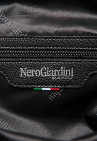 Zwarte leren interieur met een gestructureerde afwerking, voorzien van een ritssluiting en het logo "NeroGiardini MADE IN ITALY", met een klein detail van de Italiaanse vlag.